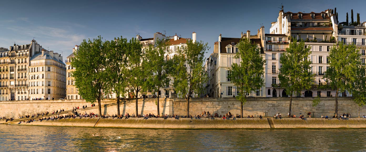 Parisiens prenant le soleil sur les quais de Seine par beau temps