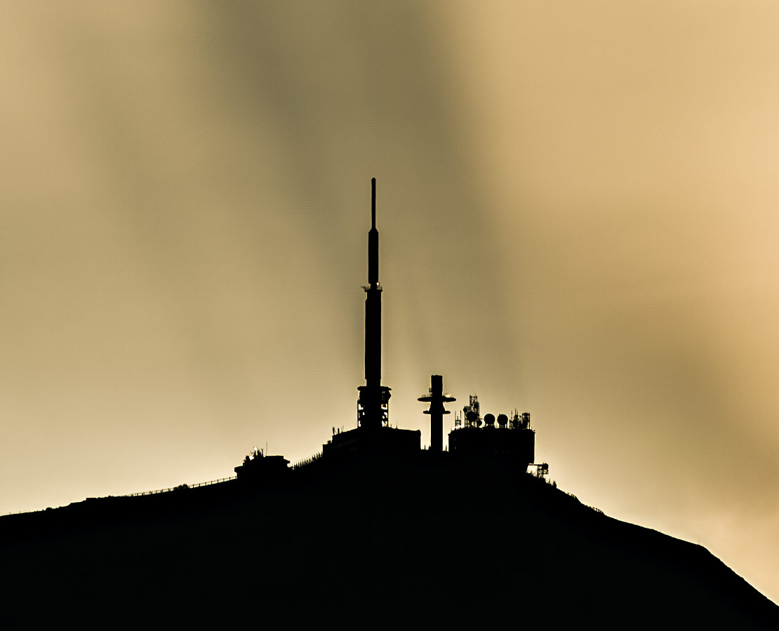 Spectre de Broken : les antennes du puy-de-Dôme se projètent en ombre chinoise sur les nuages au coucher du soleil.